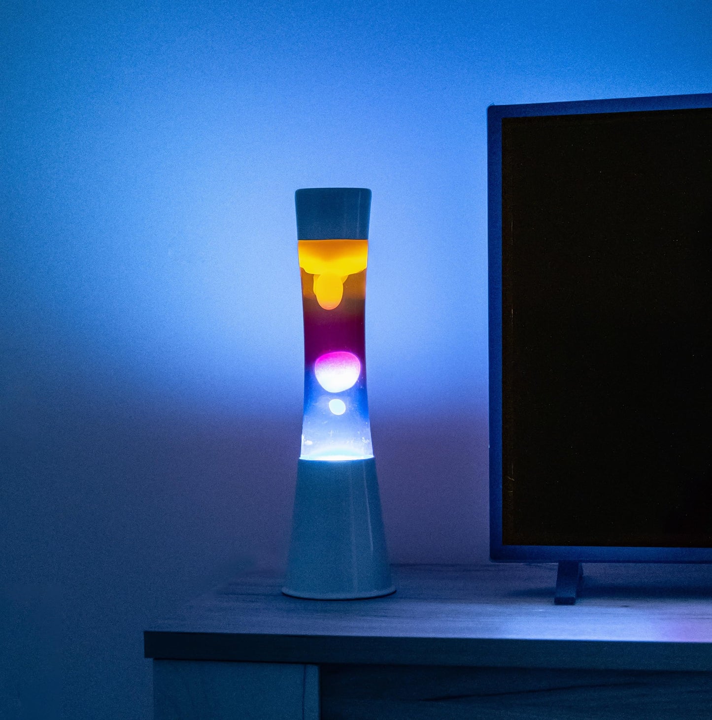 FISURA - Multicolored lava lamp. White base and glass with multicolored gradient effect. Lamp for relaxation. Comes with spare bulb. 11 cm x 11 cm x 39.5 cm.