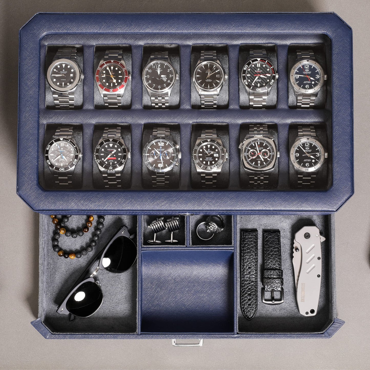 ROTHWELL 12-Slot Leather Watch Box with Valet Drawer is a luxury watch case display organizer. It features a microsuede liner and can hold men's accessories and jewelry in dark blue/grey.