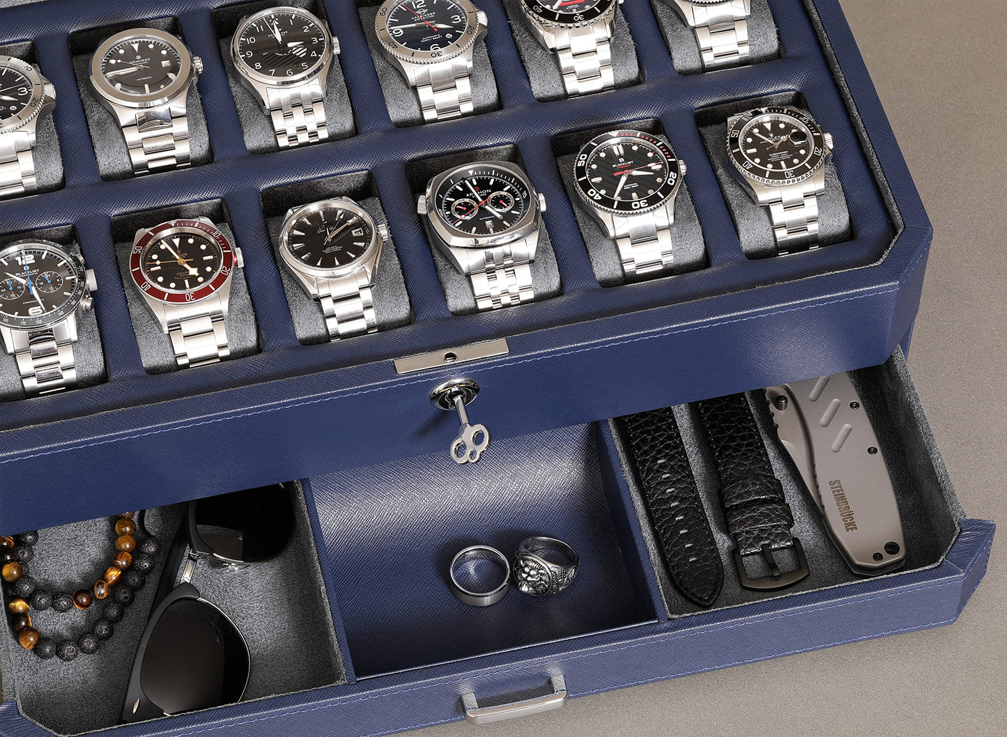 ROTHWELL 12-Slot Leather Watch Box with Valet Drawer is a luxury watch case display organizer. It features a microsuede liner and can hold men's accessories and jewelry in dark blue/grey.