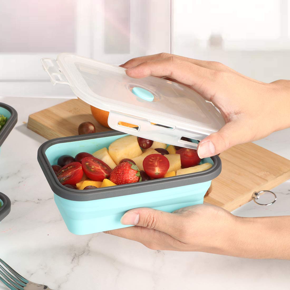 Collapsible silicone storage container with lid, portable bento box for space-saving, microwave-safe, set of 4, blue and grey.
