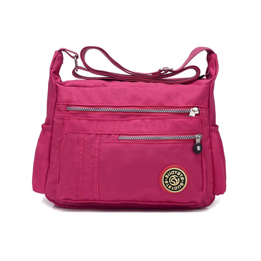 NICOLE & DORIS women's crossbody messenger bag in casual pink nylon, featuring multiple pockets and a zipper closure.
