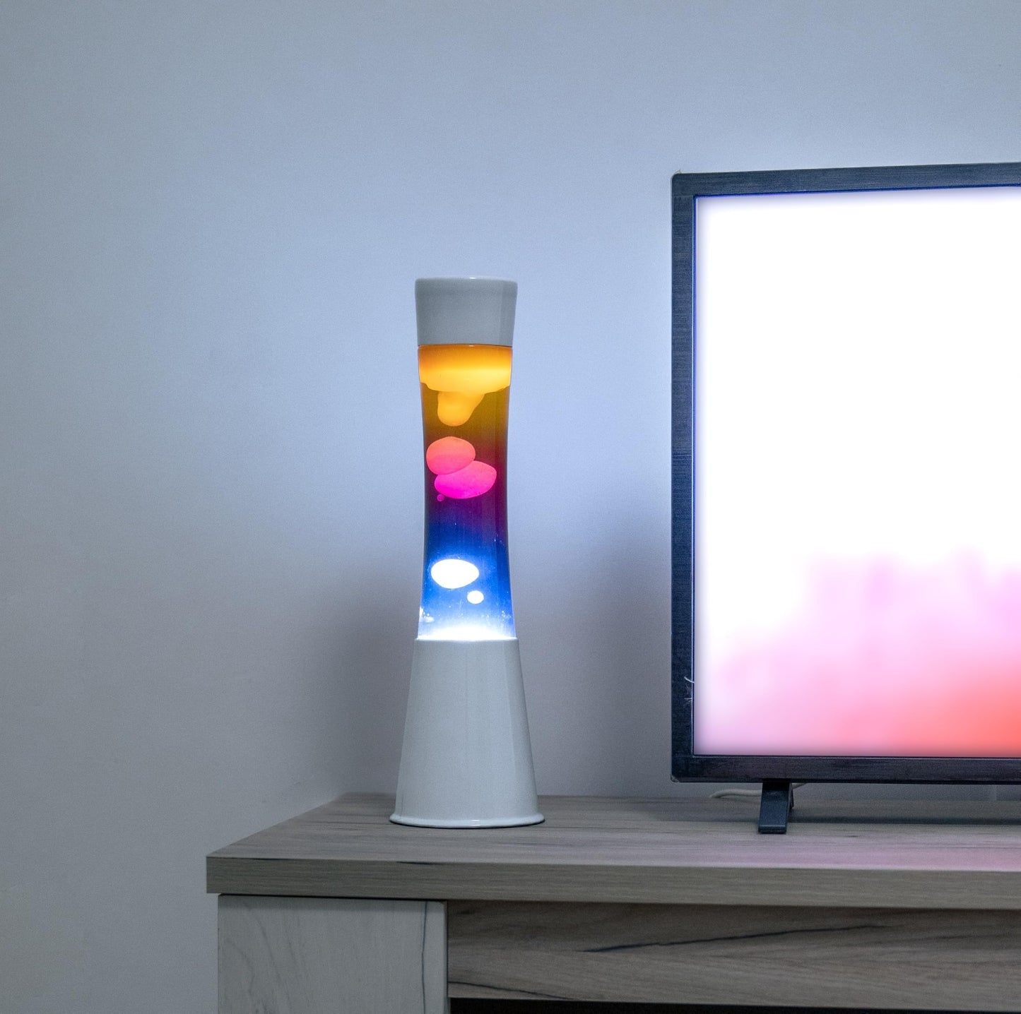 FISURA - Multicolored lava lamp. White base and glass with multicolored gradient effect. Lamp for relaxation. Comes with spare bulb. 11 cm x 11 cm x 39.5 cm.