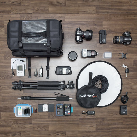 Mantona New York camera bag with internal compartments. Ideal for lenses, mirrorless cameras, and DSLRs. Provides storage for camera accessories, with rain cover and shoulder strap.
