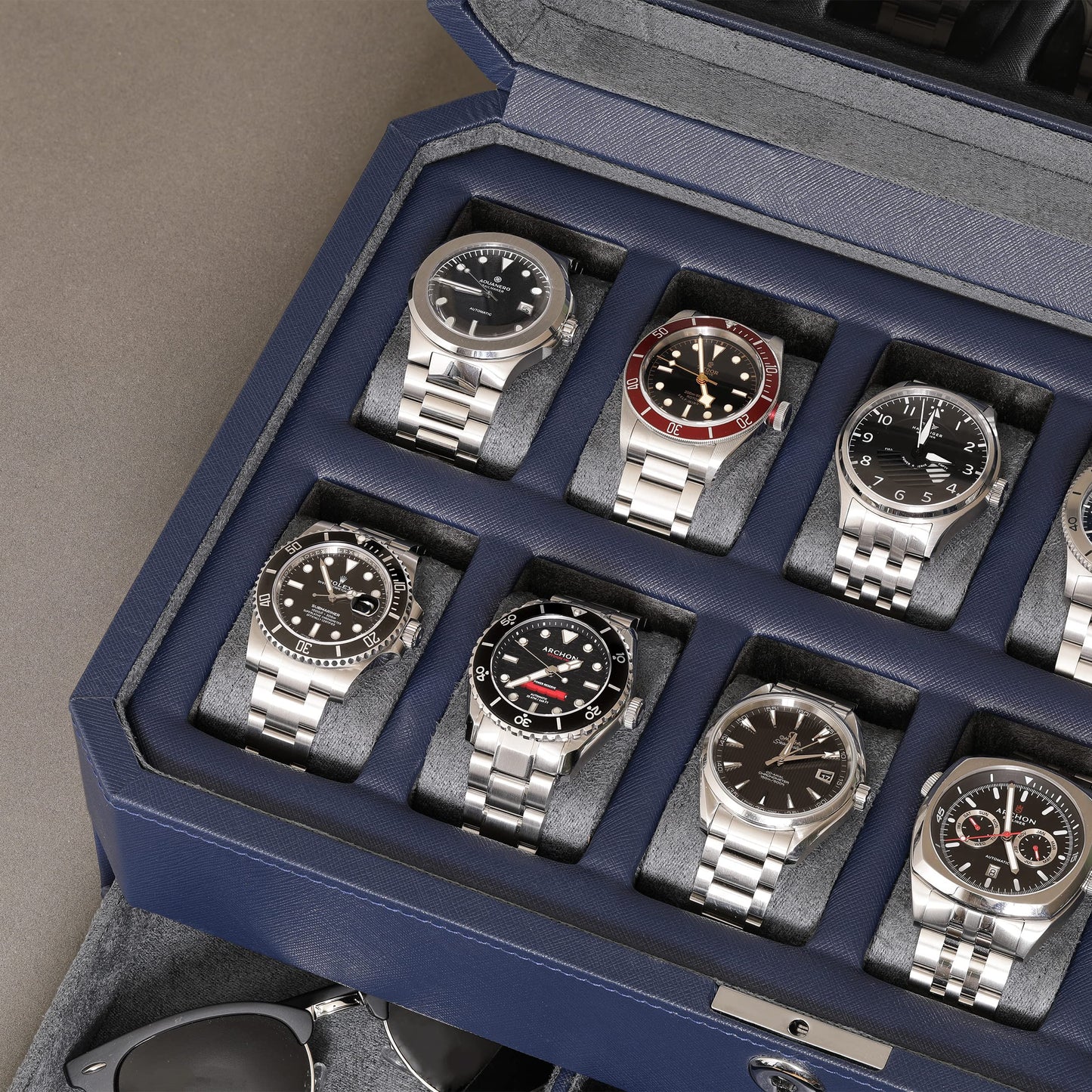 ROTHWELL 12-Slot Leather Watch Box with Valet Drawer is a luxury watch case display organizer. It features a microsuede liner and can hold men's accessories and jewelry in dark blue/grey.
